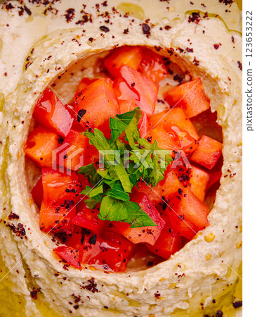 Fresh hummus topped with diced tomatoes and parsley 123653222
