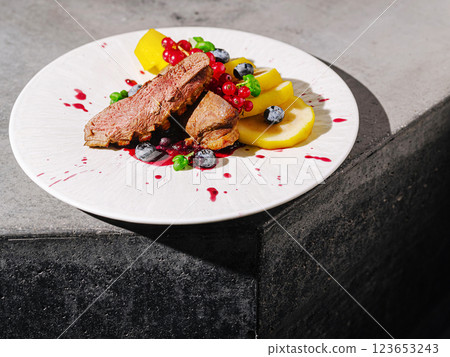 Gourmet dish with beef and fresh fruits on a modern table 123653243