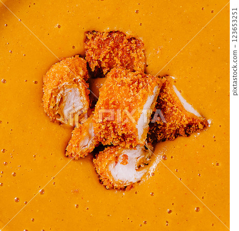 Crispy chicken pieces served in rich golden curry sauce Crispy chicken pieces served in rich golden curry sauce 123653251