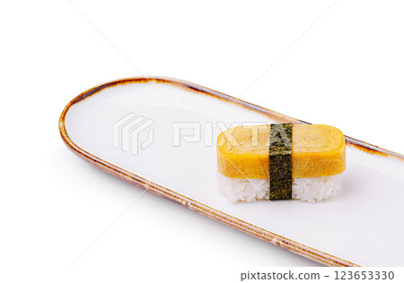 Delicate sushi featuring tamago on a minimalist white plate Delicate sushi featuring tamago on a minimalist white plate 123653330