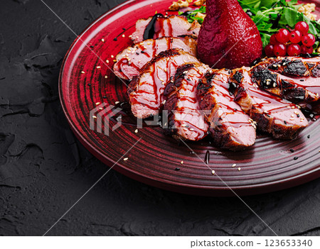 Gourmet dish featuring grilled duck breast with fruits and greens 123653340