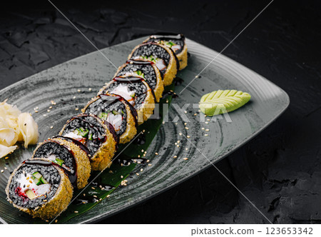 Unique sushi rolls served on a sleek plate with wasabi and ginger 123653342