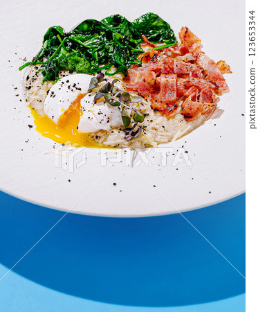 Delicious breakfast bowl featuring poached egg, spinach, and bacon Delicious breakfast bowl featuring poached egg, spinach, and bacon 123653344