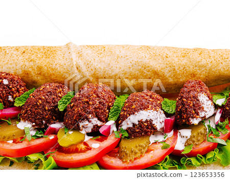 Savory falafel wrap filled with fresh vegetables and sauce Savory falafel wrap filled with fresh vegetables and sauce 123653356