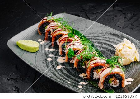 Delicious sushi rolls served on a sleek black plate Delicious sushi rolls served on a sleek black plate 123653357