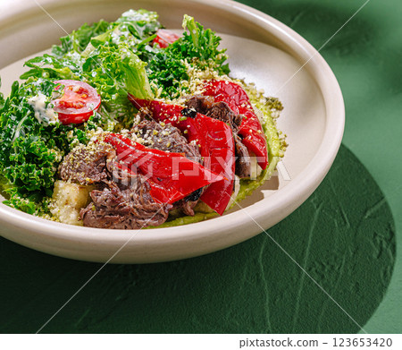 Colorful salad with beef, tomatoes, and greens on a plate 123653420