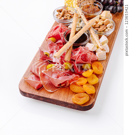 Charcuterie board with assorted meats and snacks for a gathering Charcuterie board with assorted meats and snacks for a gathering 123653421