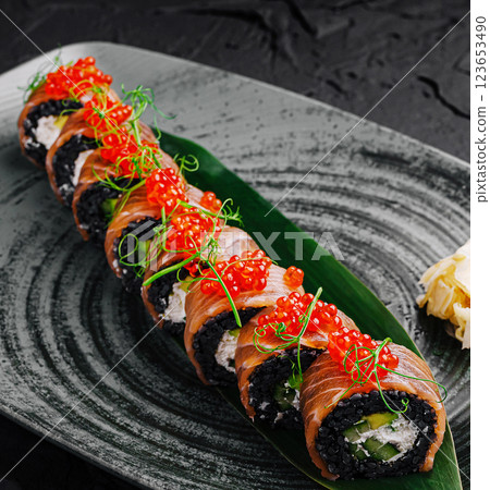 Sushi rolls garnished with red caviar on a decorative plate Sushi rolls garnished with red caviar on a decorative plate 123653490