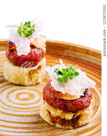 Delicious gourmet tartare served on crispy crust with garnishes Delicious gourmet tartare served on crispy crust with garnishes 123653562