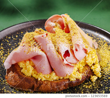 Savory breakfast dish featuring scrambled eggs and ham slices Savory breakfast dish featuring scrambled eggs and ham slices 123653569