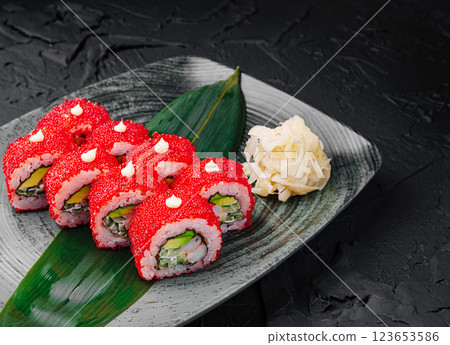 Colorful sushi rolls displayed on a dark textured plate 123653586
