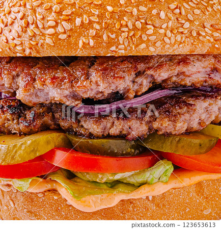 Delicious burger topped with fresh vegetables on a sesame bun 123653613