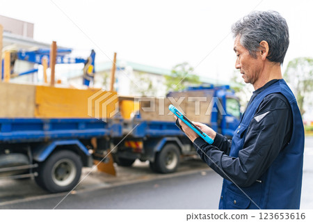A craftsman holding a tablet and inspecting the construction site 123653616