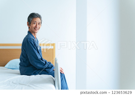 Smiling senior man sitting on the bed 123653629