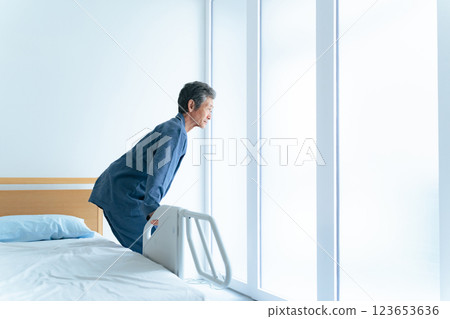 Senior man getting up from nursing bed Senior man getting up from nursing bed 123653636