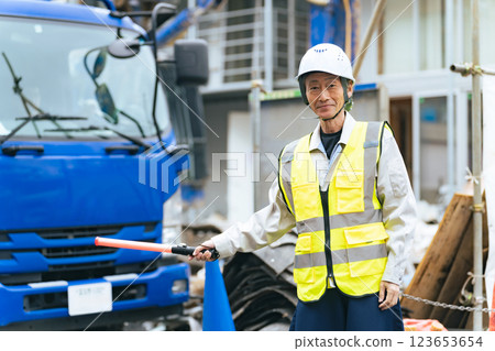 An elderly construction worker directing traffic on the road An elderly construction worker directing traffic on the road 123653654