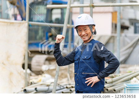 A craftsman standing in front of a construction site with a smile 123653658