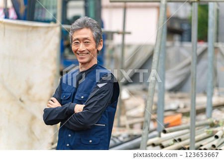 A craftsman standing in front of a construction site with a smile 123653667