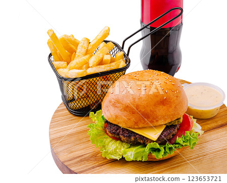 Juicy hamburger with fries and drink on wooden platter 123653721
