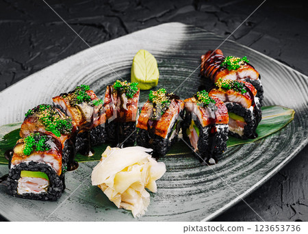 Sushi rolls presented decoratively with garnishes on a plate 123653736