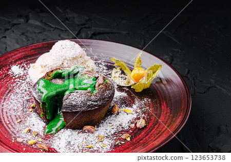Delicious molten cake with vibrant green sauce and ice cream 123653738