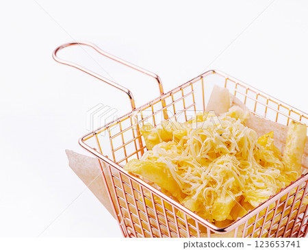 Delicious golden fries topped with melted cheese in a basket 123653741
