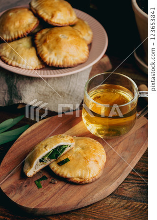Oven Baked Pastries Filled with Chives and Mushrooms with Cup of Green Tea Oven Baked Pastries Filled with Chives and Mushrooms with Cup of Green Tea 123653841