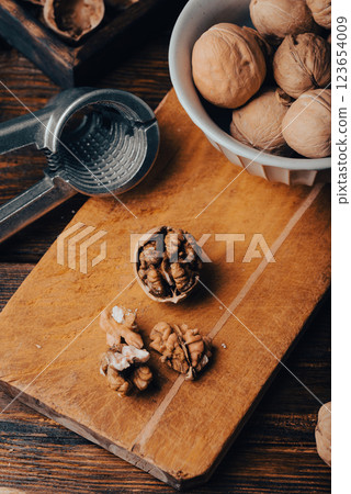 Cracked walnuts on cutting board 123654009