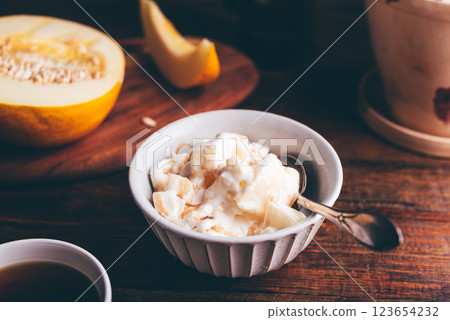 Bowl of Ice Cream Mixed with Melon and Covered with Berry Syrup 123654232
