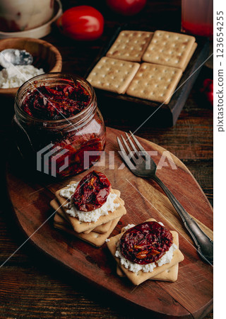 Crackers with cream cheese and sundried tomatoes 123654255
