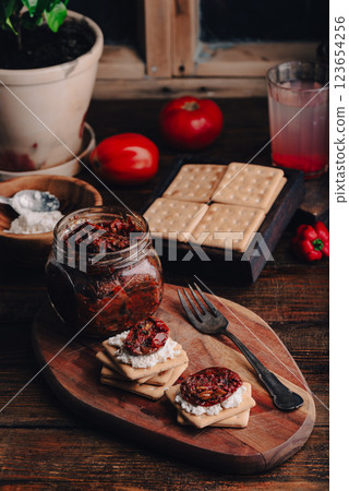 Light snack with crackers, sun-dried tomatoes and cream cheese 123654256