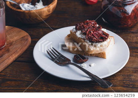 Toast with cream cheese and sundried tomatoes on plate 123654259