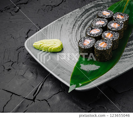 Sushi rolls served with wasabi on a textured plate Sushi rolls served with wasabi on a textured plate 123655046