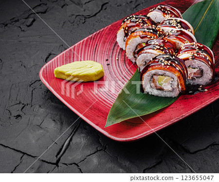 Delicious sushi rolls presented on a vibrant red plate 123655047