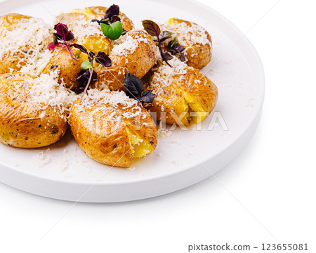 Delicious baked potatoes topped with cheese and herbs on a white plate Delicious baked potatoes topped with cheese and herbs on a white plate 123655081
