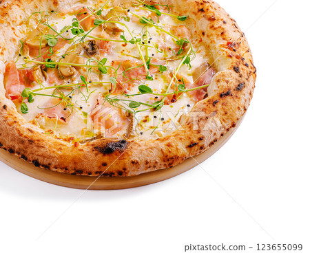 Freshly baked pizza with toppings and herbs on a wooden base Freshly baked pizza with toppings and herbs on a wooden base 123655099