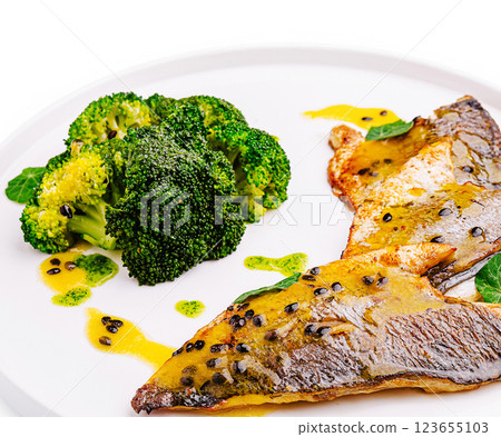Delicious grilled fish with broccoli and citrus sauce on a plate 123655103