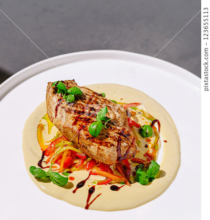 Grilled chicken breast served on creamy sauce with vegetables 123655113