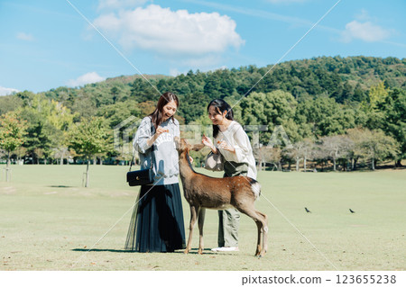 一位女士（朋友）在奈良公園餵鹿鹿餅 123655238