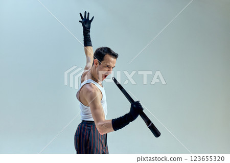 Dramatic intensity captured in movement, raised hand and sharp expression embodying theatrical flair and artistic mastery against neutral-toned studio setting. 123655320