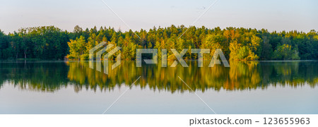 The serene Trebonsko Pond System showcases lush greenery reflecting beautifully in calm waters, highlighting the natural beauty of this UNESCO Biosphere Reserve in South Bohemia. 123655963