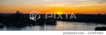 The skyline of Belgrade is silhouetted against the vibrant sunset over the Sava River. The warm colors reflect on the water, creating a tranquil atmosphere at Kalamegdan fortress. The skyline of Belgrade is silhouetted against the vibrant sunset over the Sava River. The warm colors reflect on the water, creating a tranquil atmosphere at Kalamegdan fortress. 123655981