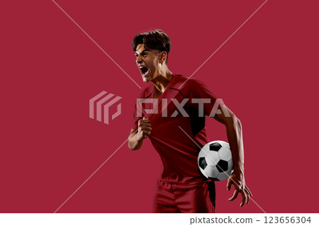 Energetic collage. Determined football athlete dressed in red expressing victory, gripping jersey, radiating power and energy against red background. 123656304