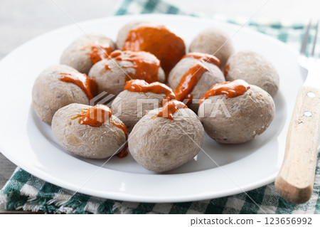Papas arrugadas with mojo on wooden table. Traditional Canary Islands food. Papas arrugadas with mojo on wooden table. Traditional Canary Islands food. 123656992