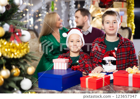 Smiling family celebrating Christmas and giving each other gifts Smiling family celebrating Christmas and giving each other gifts 123657347