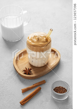 Korean whipped drink Dalgona coffee on a woden plate on a concrete background with spice Korean whipped drink Dalgona coffee on a woden plate on a concrete background with spice 123657396