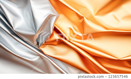 Crumpled metallic foil in silver and gold tones with sharp folds and reflective surfaces, creating an abstract textured background. Crumpled metallic foil in silver and gold tones with sharp folds and reflective surfaces, creating an abstract textured background. 123657546