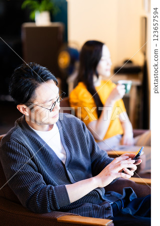一個男人在咖啡館看智能手機 123657594