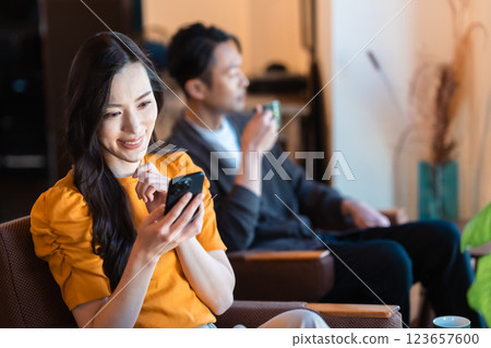 年輕女子在咖啡館裡查看她的智慧型手機 123657600
