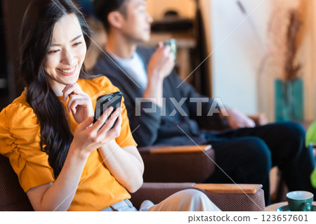 年輕女子在咖啡館裡查看她的智慧型手機 123657601